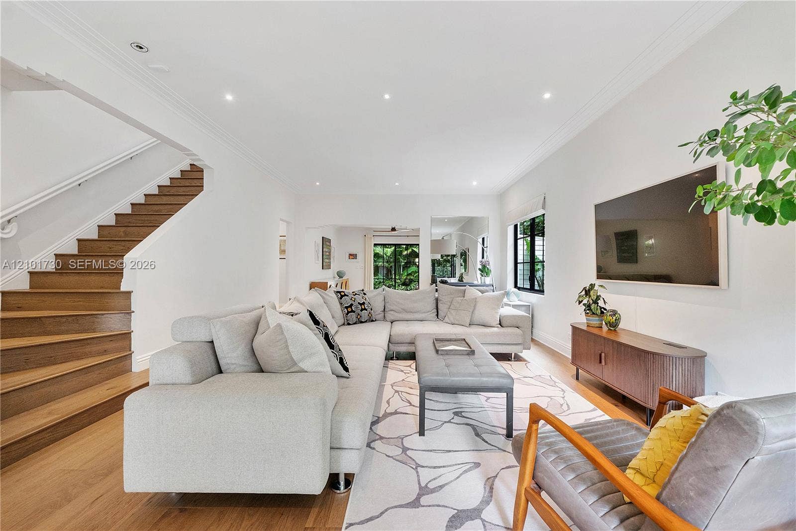 435 W 51st Street, Miami Beach, FL 33140 Living area featuring wood-finish flooring, staircase with wood treads, recessed lighting, crown molding, and large window with dark frame
