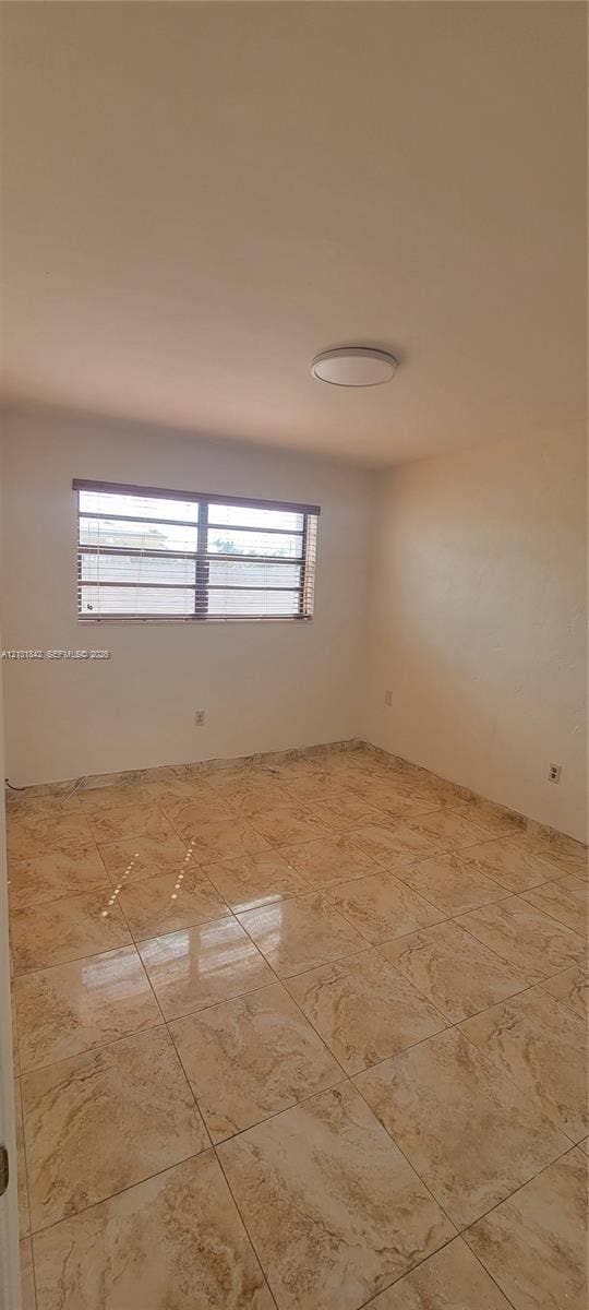 5795 W 13th Court, Hialeah, Hialeah, FL 33012 Interior room featuring large-format ceramic tile flooring, neutral wall tones, and a flush-mount ceiling light fixture