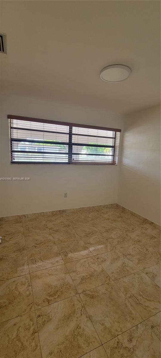 5795 W 13th Court, Hialeah, Hialeah, FL 33012 Neutral-toned tile flooring, horizontal window blinds, and a flush-mount circular ceiling fixture