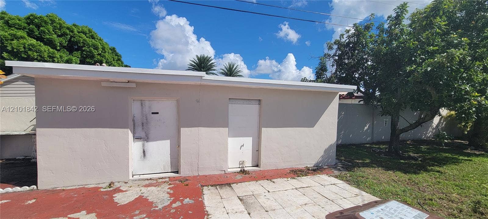 5795 W 13th Court, Hialeah, Hialeah, FL 33012 Detached exterior structure with smooth stucco siding, flat roofline, two solid-core doors, and paved patio area