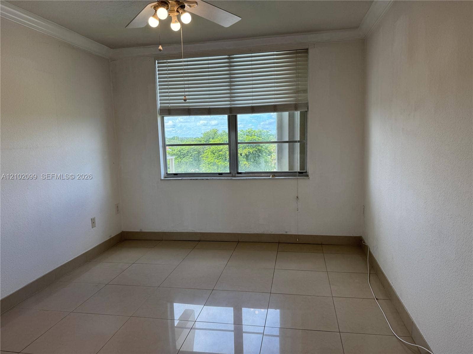 13120 SW 92nd Avenue, #B-PH1, Miami, Miami, FL 33176 Large-format tile flooring, crown molding, expansive window with horizontal blinds, and ceiling fan with integrated lighting