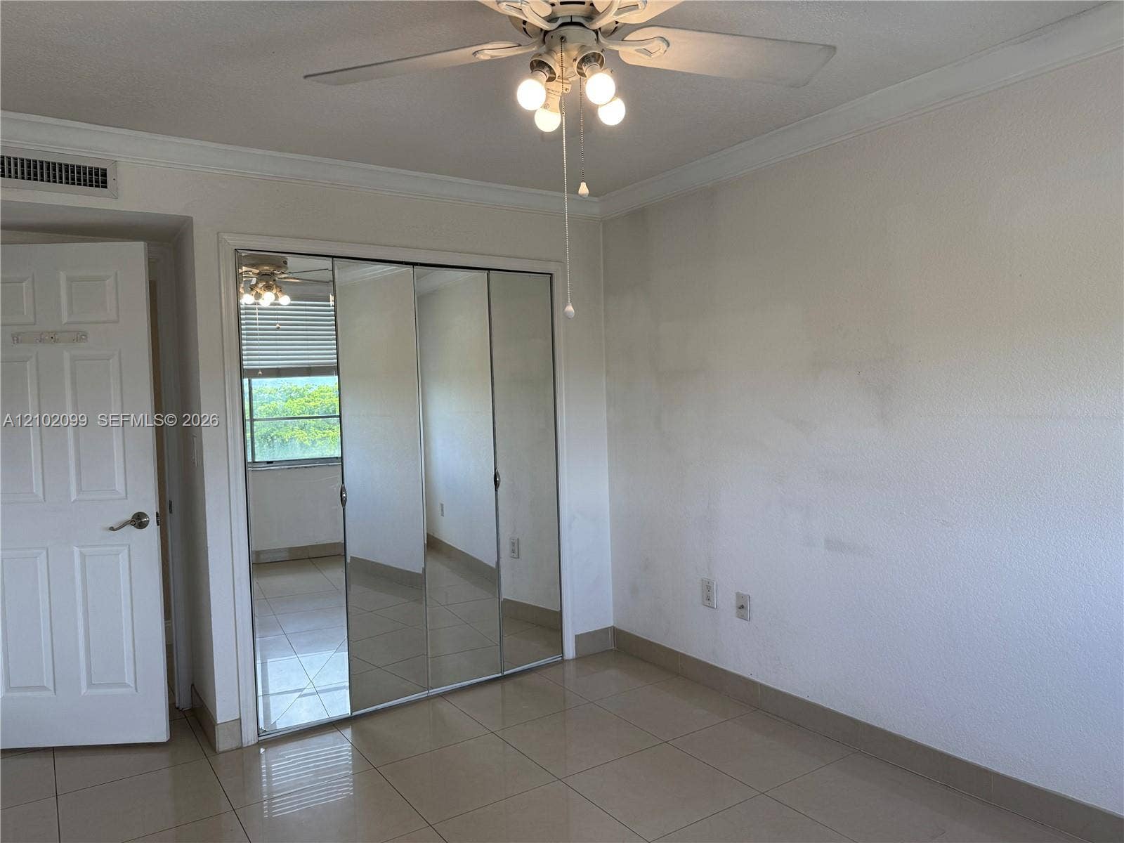 13120 SW 92nd Avenue, #B-PH1, Miami, Miami, FL 33176 Room featuring mirrored sliding-door closet, neutral tile flooring, multi-panel interior door, and overhead ceiling fan with light fixture