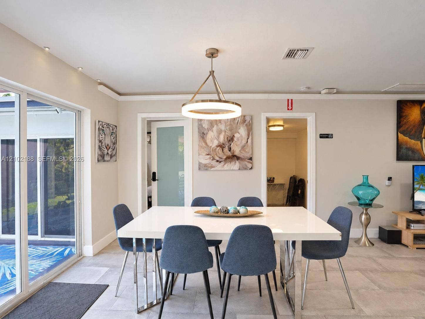 Dining area featuring large-format tile flooring, a circular tiered chandelier, recessed ceiling lighting, and expansive sliding glass doors