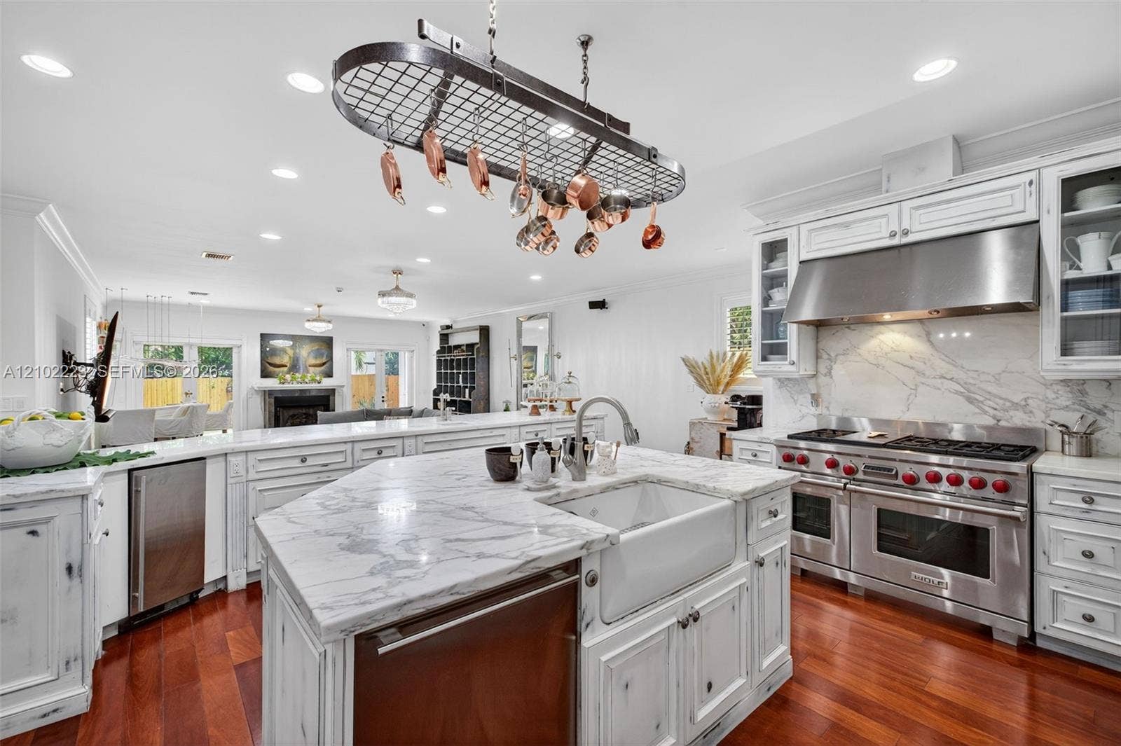A chefs kitchen with personality and character featuring distinctive, distressed, finish cabinetry, Premium, Wolf, Appliances, and beautiful marble stone countertops a unique blend of rustic charm and modern culinary luxury creates a space thats as inviting as it is functional.