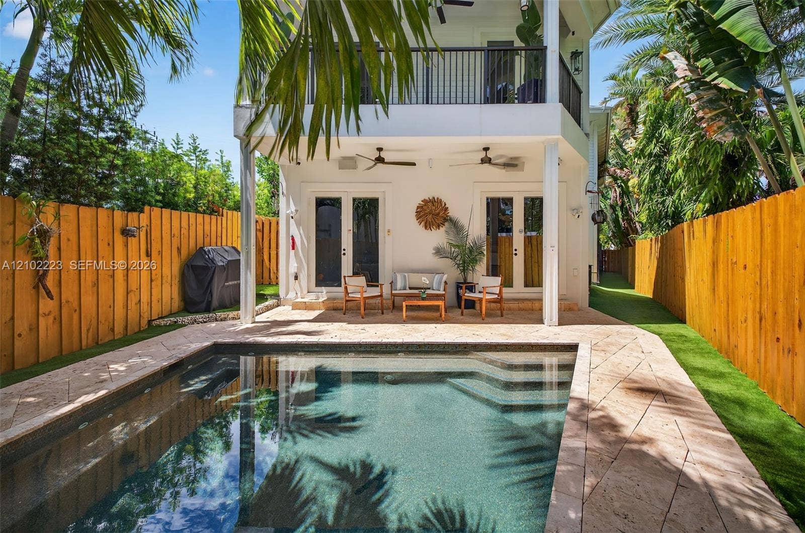 Your own slice of tropical paradise designed for effortless enjoyment and minimal maintenance. This charming outdoor oasis features a heated saltwater pool with soothing waterfall feature lush, tropical surroundings, and a covered patio, perfect for lounging or alfresco, entertaining as sunlight shift throughout the day beautiful Palm reflections dance across the water creating and ever-changing Tropical backdrop all the pleasures of South Florida Outdoor, living without the demands of extensive upkeep.