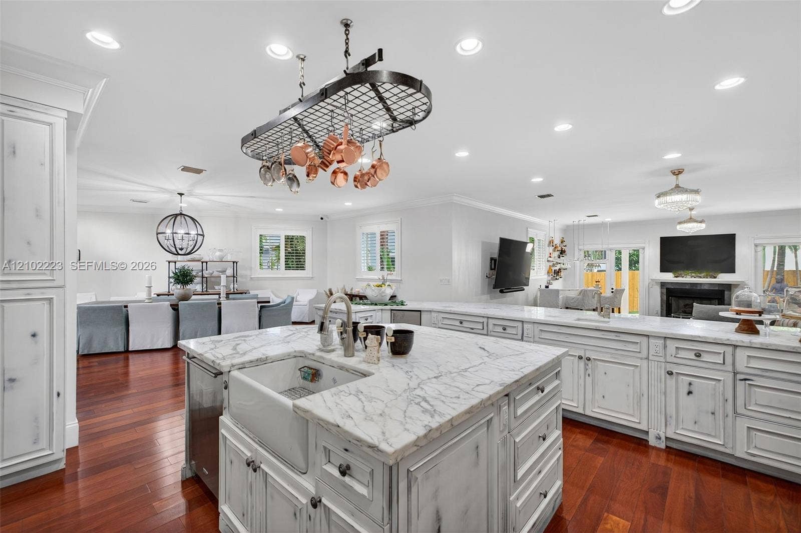 A kitchen design with the culinary enthusiast in mind, beautiful stone countertops, a farmhouse sink and a distinctive, suspended pot rack at character and functionality while the expensive open layout keeps everyone connected whether preparing a gourmet meal or entertaining guests.