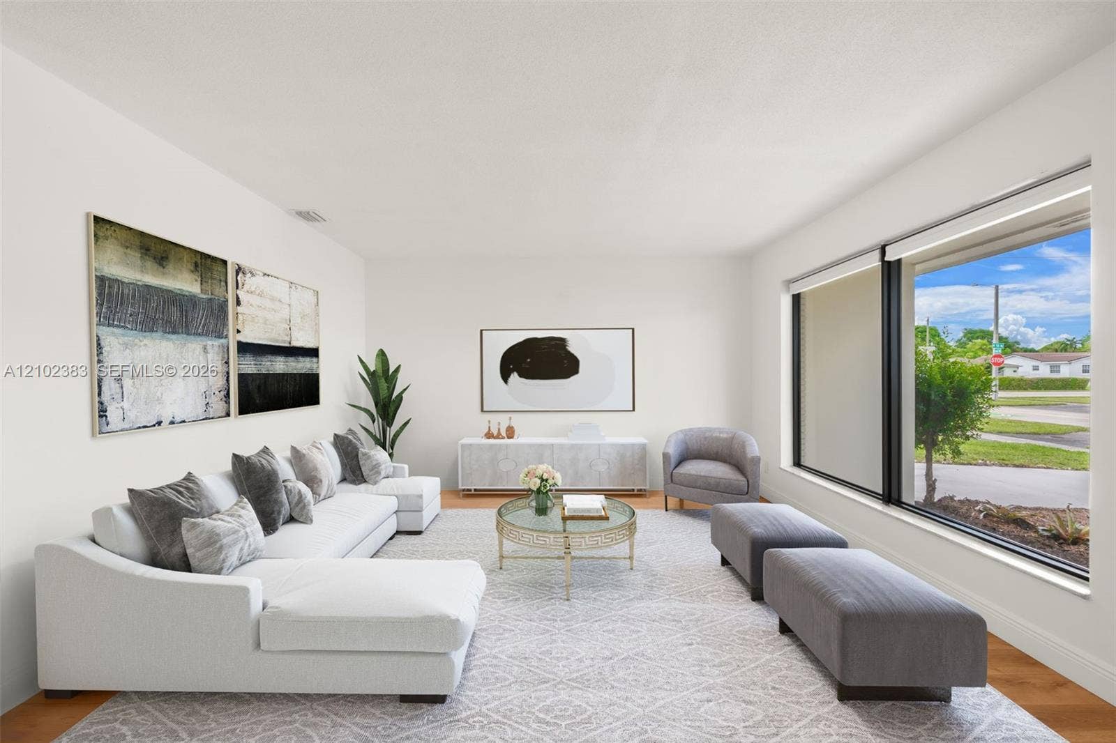 Living area featuring large windows with black frames and wood-finish flooring