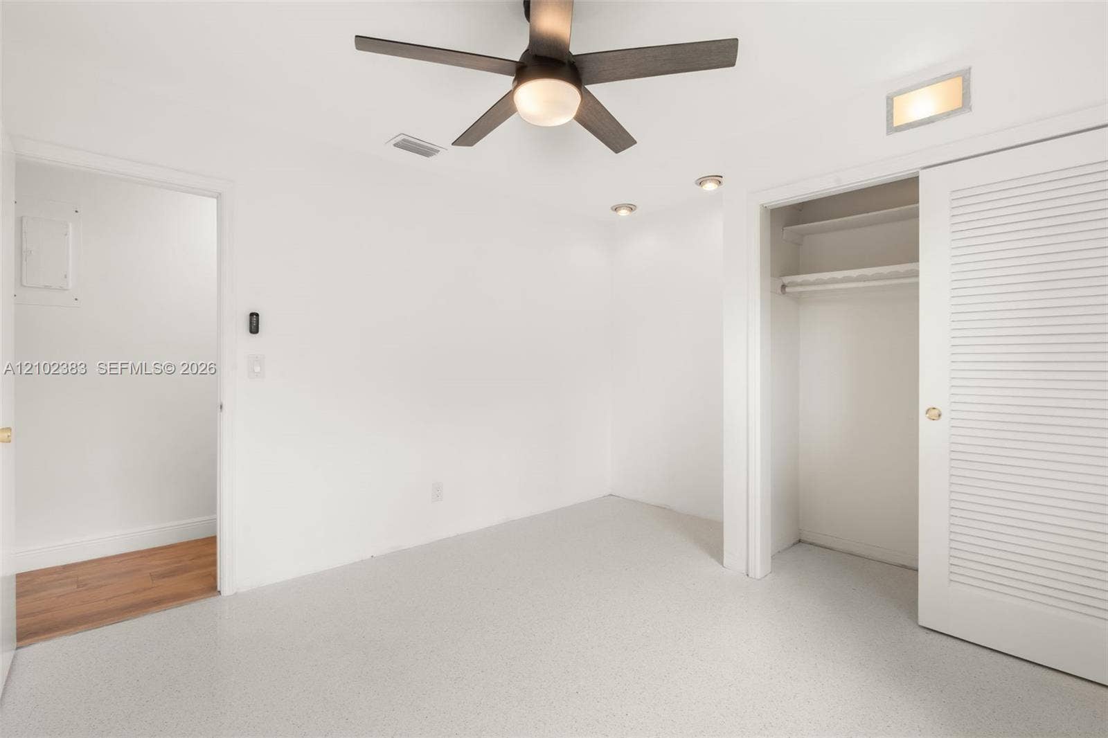 Bedroom 2 featuring a ceiling fan with integrated light, recessed lighting, neutral flooring, and a closet with louvered double doors and built-in shelving