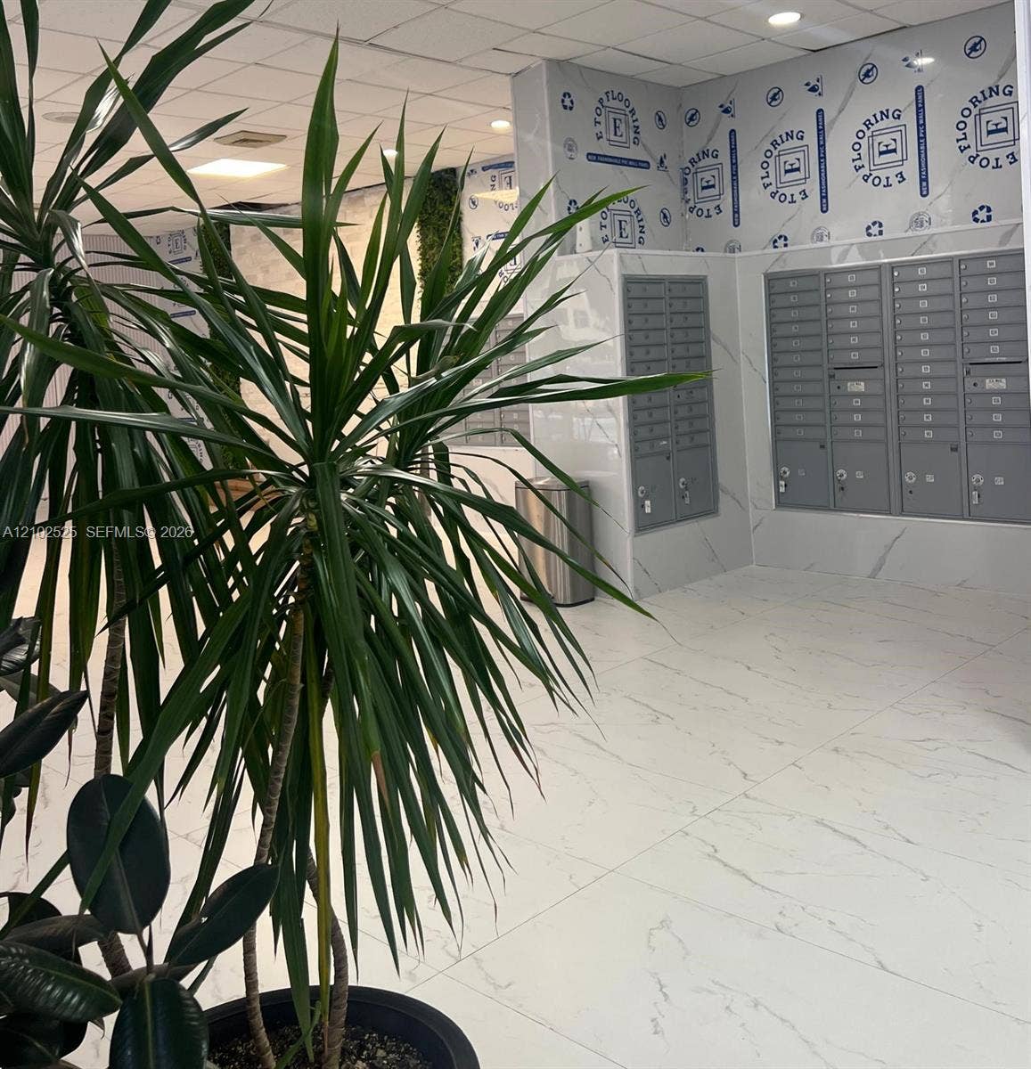 Lobby featuring large-format stone-finish flooring, full-height wall cladding, and integrated metal mailboxes with individual locks