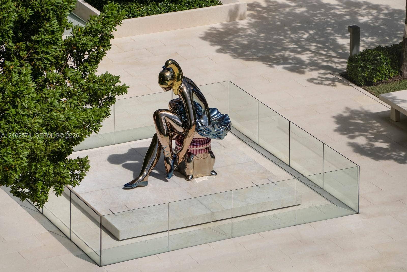 10201 Collins Avenue, #502, Bal Harbour, FL 33154 Communal courtyard featuring large-scale metallic sculpture, raised stone pedestal, perimeter glass railing, and smooth stone paving