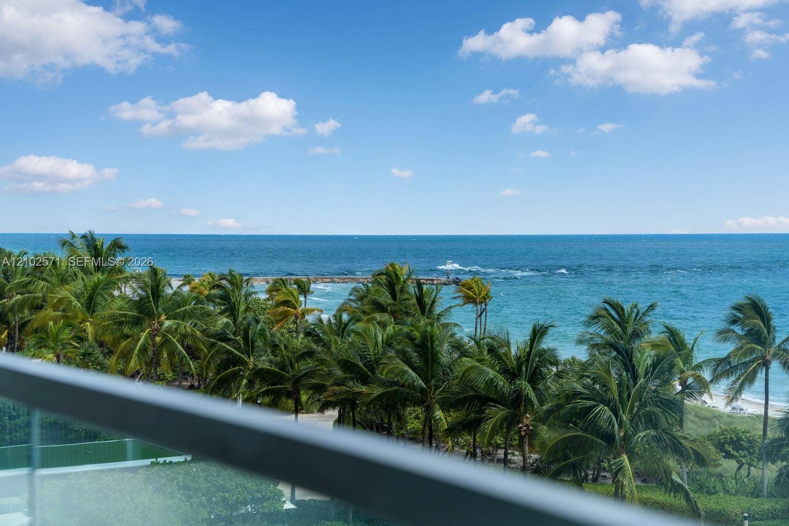 10201 Collins Avenue, #502, Bal Harbour, FL 33154 Balcony featuring a glass railing and direct ocean exposure with mature palm trees