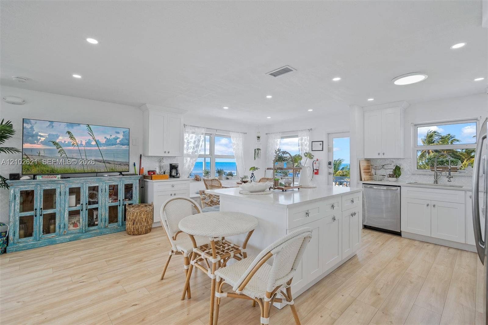 Kitchen featuring white cabinetry, a kitchen island, stainless steel appliances, wood-finish flooring, and recessed lighting