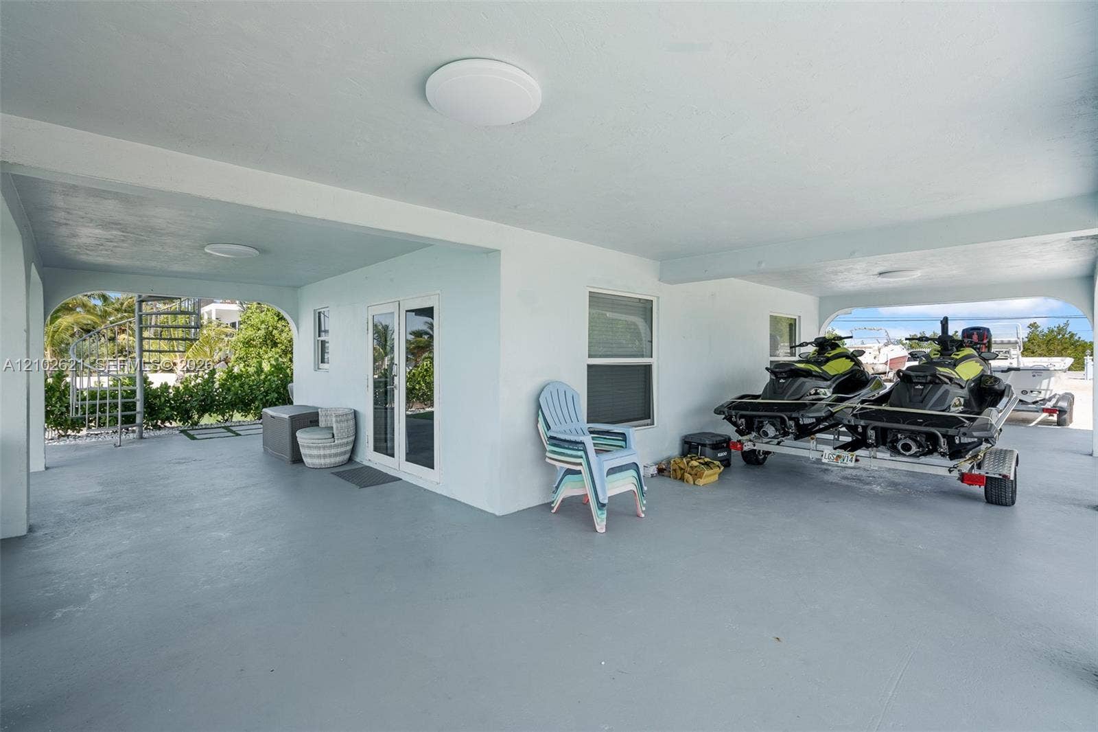Covered open-air space with concrete flooring, recessed lighting, and white walls