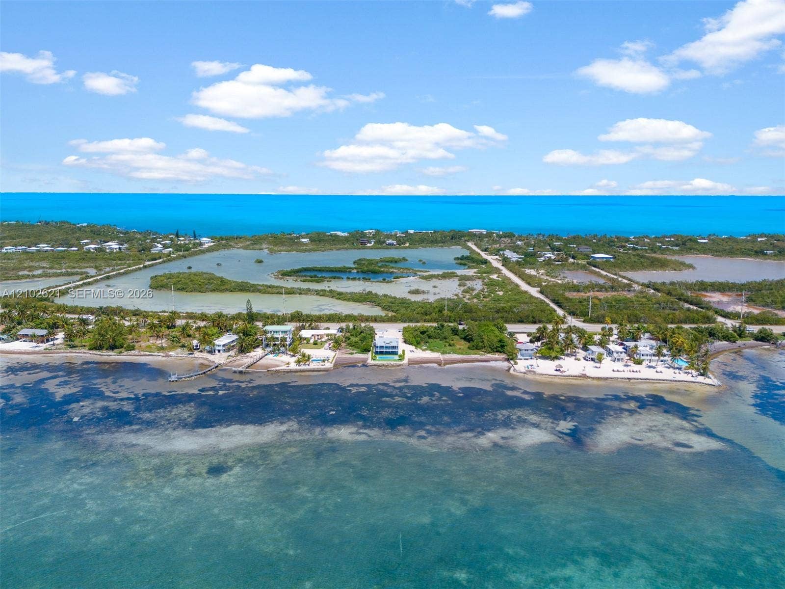 Waterfront property with direct access to the ocean, featuring a private pier and multiple residential structures