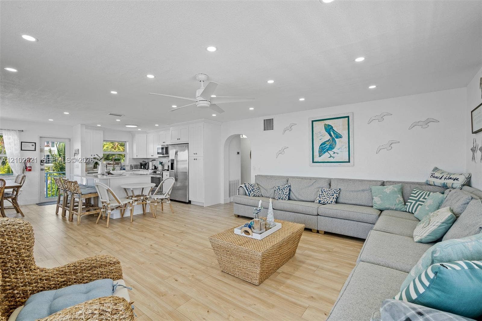 Open-concept living area with wood-finish flooring, recessed lighting, and a ceiling fan