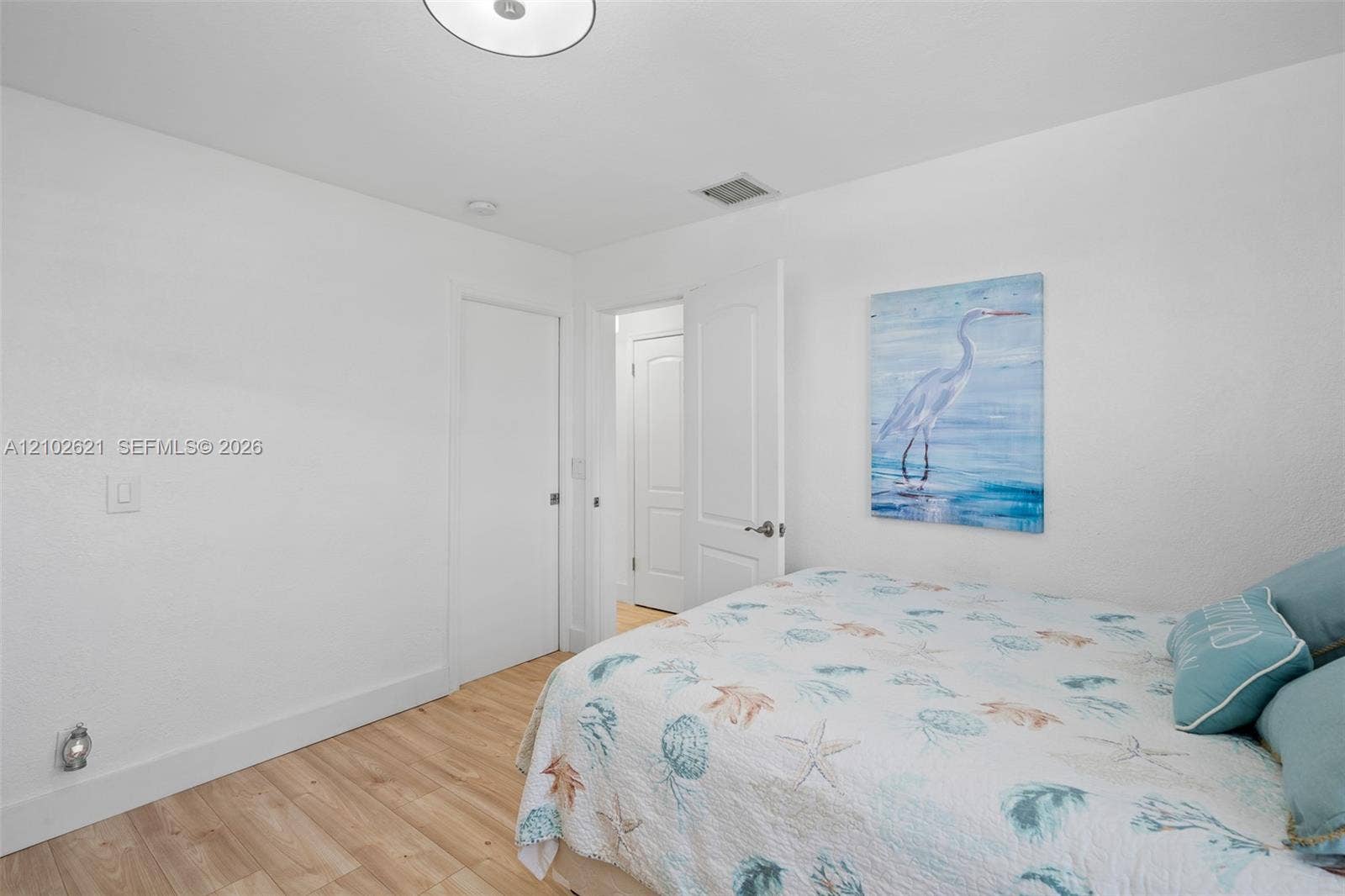 Recessed ceiling lighting, wood-finish flooring, and white interior doors