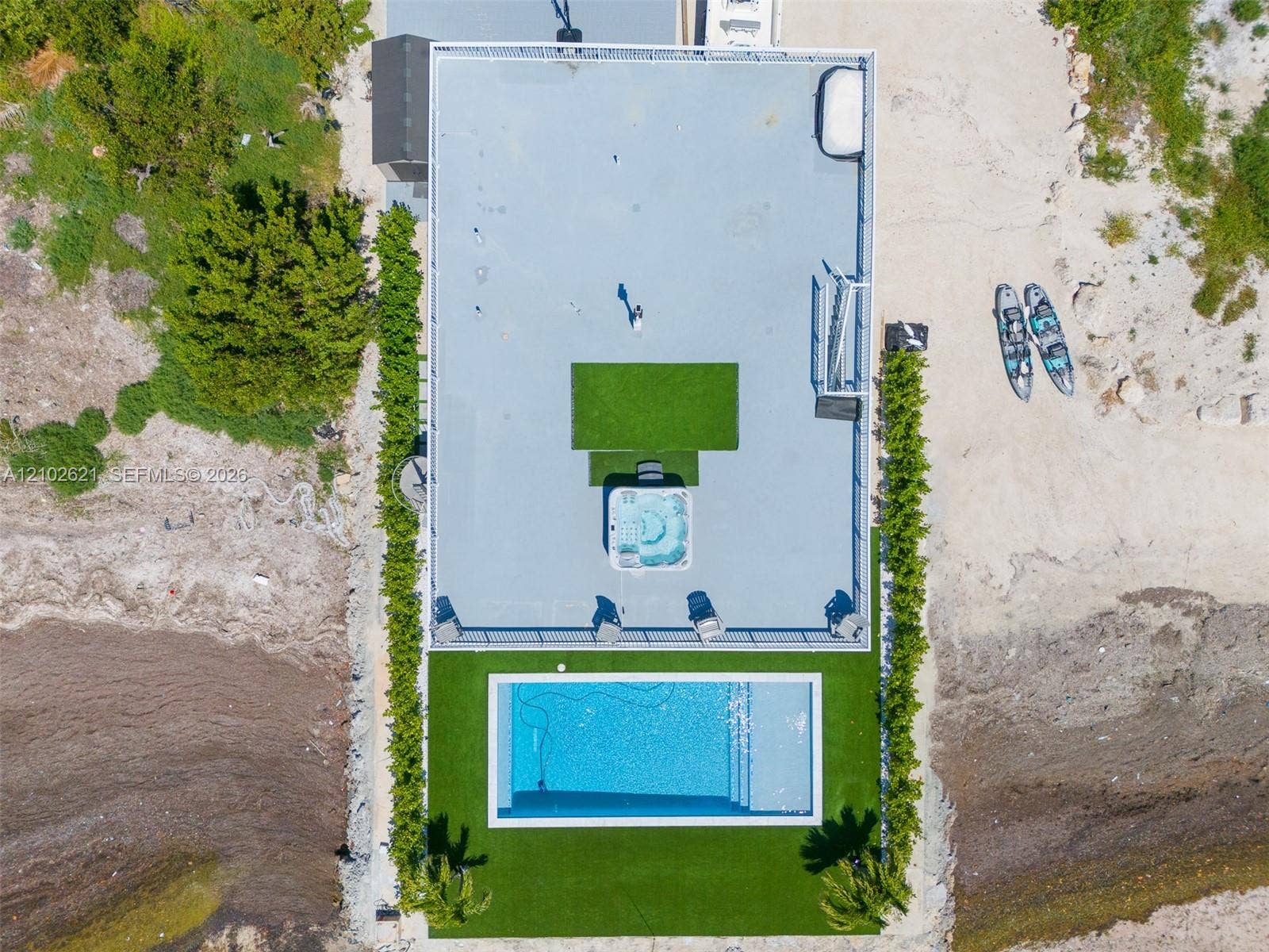 Rooftop deck featuring a spa, artificial turf areas, an in-ground swimming pool, and established perimeter plantings