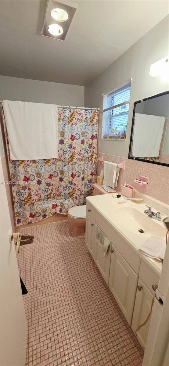 2800 NE 203rd Street, #8, Aventura, FL 33180 Bathroom featuring a vanity with integrated sink, rectangular mirror, ceiling-mounted light fixture, and tiled flooring