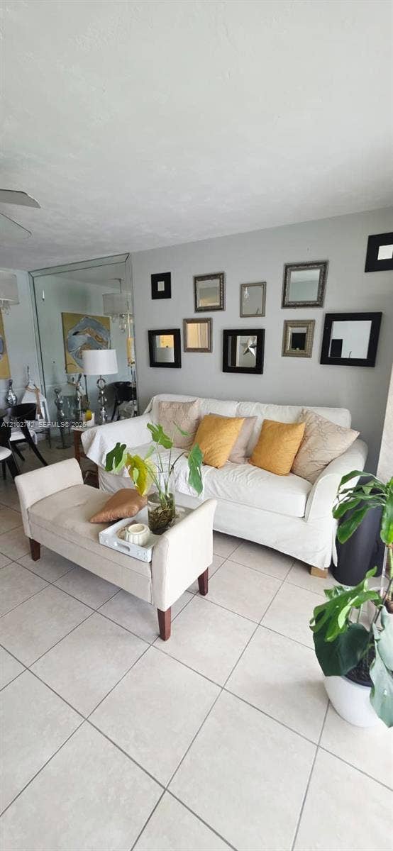 2800 NE 203rd Street, #8, Aventura, FL 33180 Living area featuring large-format ceramic tile flooring and a full-height mirrored wall panel