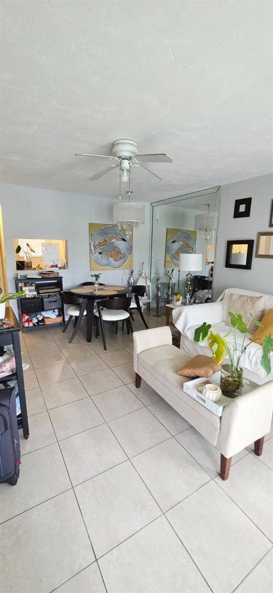 2800 NE 203rd Street, #8, Aventura, FL 33180 Ceramic tile flooring, mirrored wall accent, ceiling fan with integrated lighting, and pass-through wall opening