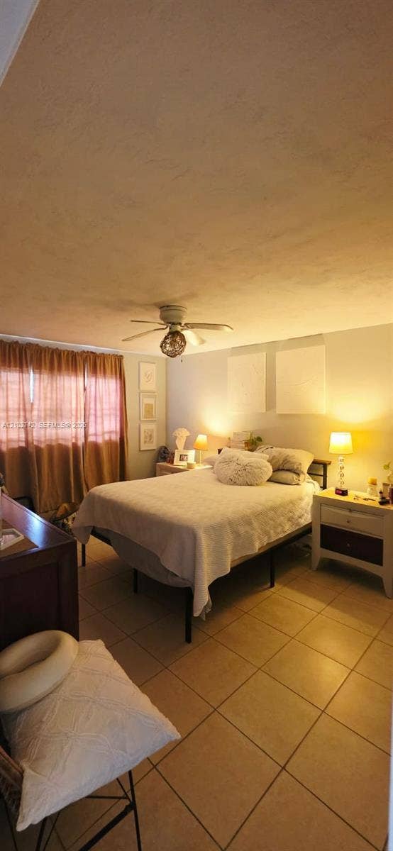 2800 NE 203rd Street, #8, Aventura, FL 33180 Neutral-toned room featuring oversized tile flooring and a ceiling-mounted light fixture with integrated fan