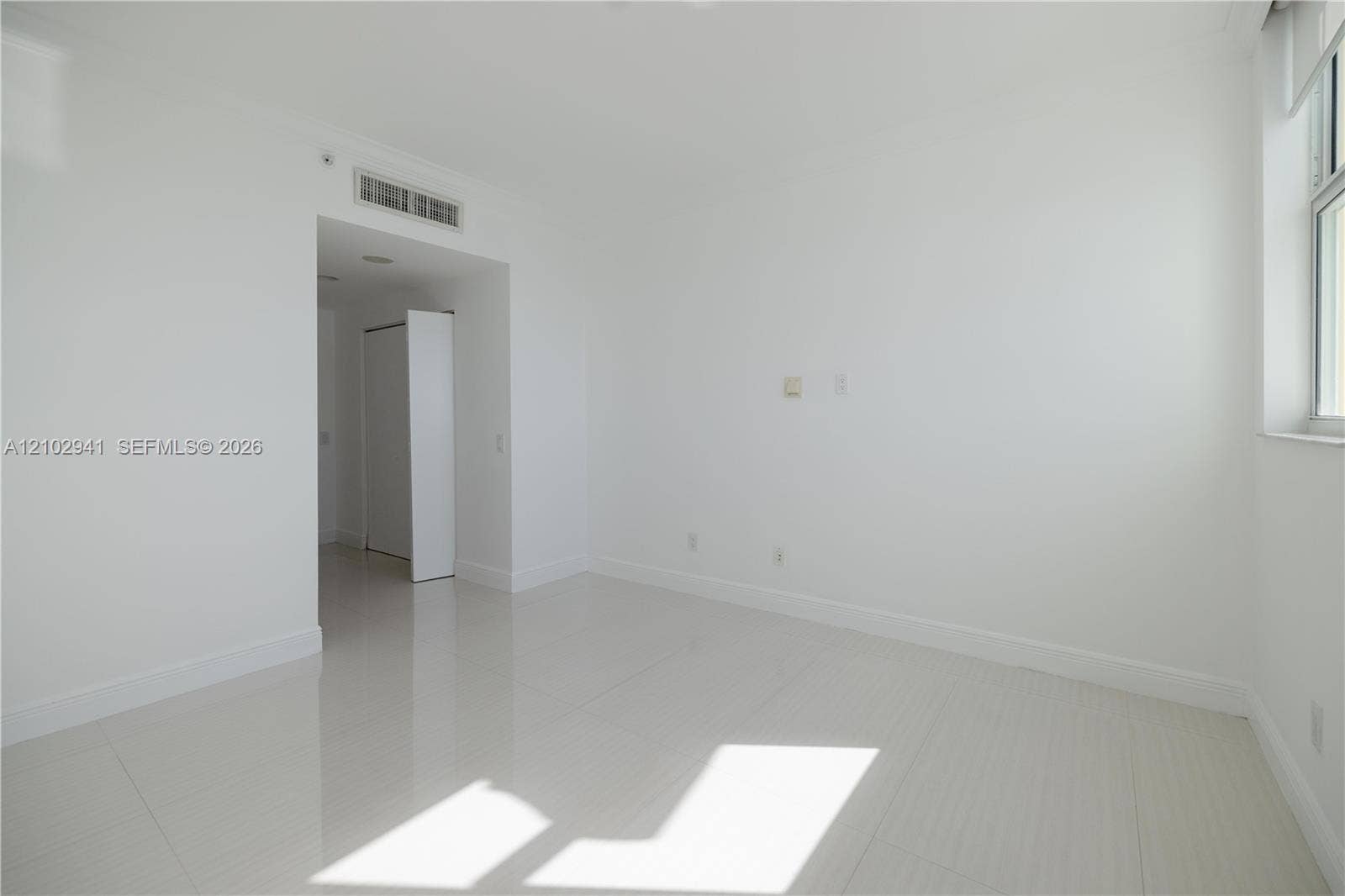 2475 Brickell Avenue, #1807, Miami, FL 33129 Interior space featuring polished tile flooring, neutral wall finishes, and a window with white casing