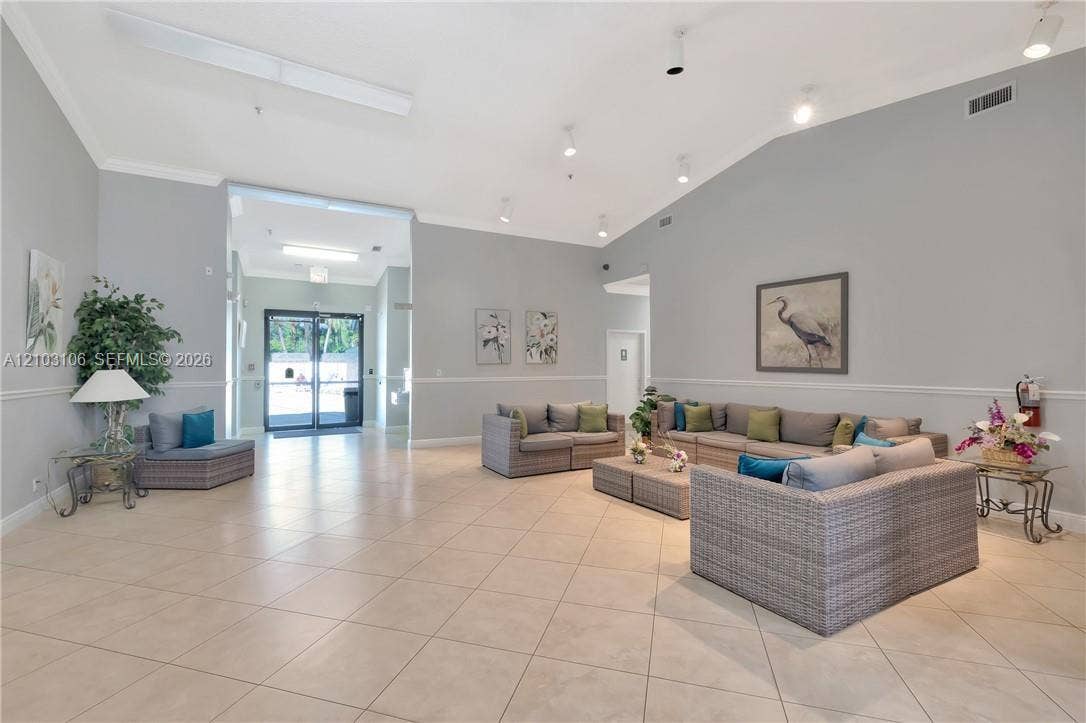 2230 N Cypress Bend Drive, #308, Pompano Beach, Pompano Beach, FL 33069 Spacious interior area featuring high vaulted ceilings, large-format tile flooring, recessed lighting, and chair rail molding