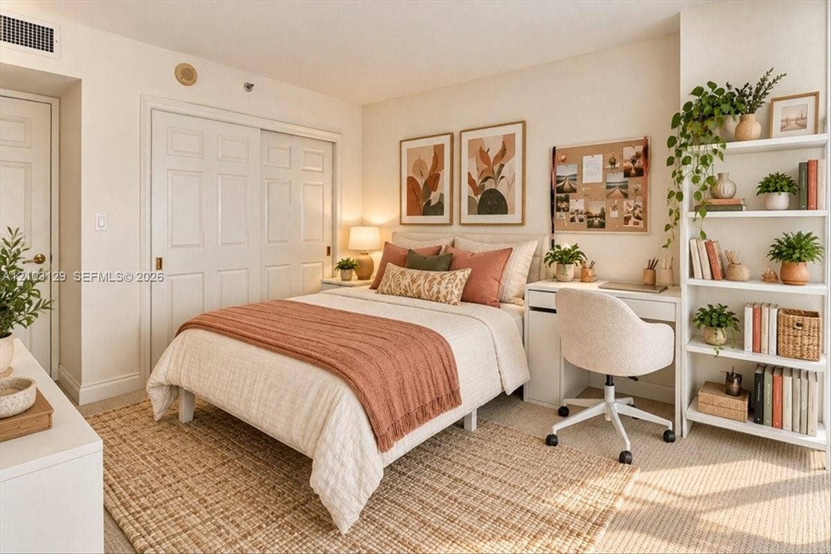 1627 Brickell Avenue, #2005, Miami, FL 33129 Neutral-toned carpeting, built-in shelving, and dual sliding closet doors with recessed handles