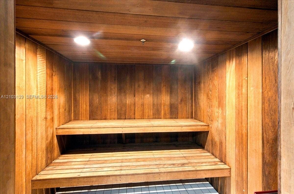 1627 Brickell Avenue, #2005, Miami, FL 33129 Sauna featuring natural wood wall paneling, tiered built-in wood bench seating, and recessed ceiling lighting