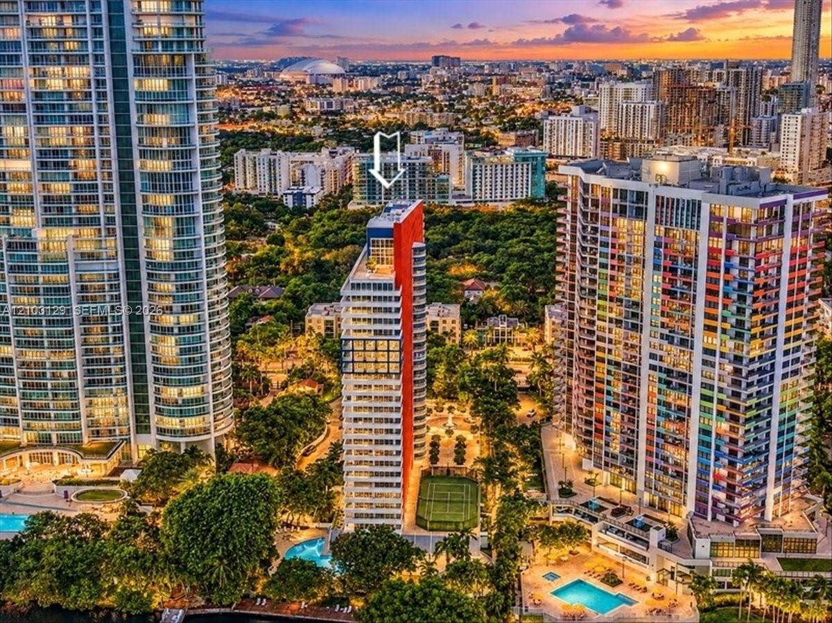 1627 Brickell Avenue, #2005, Miami, FL 33129 High-rise tower featuring a distinctive red facade, rooftop terrace, onsite tennis court, and ground-level pool