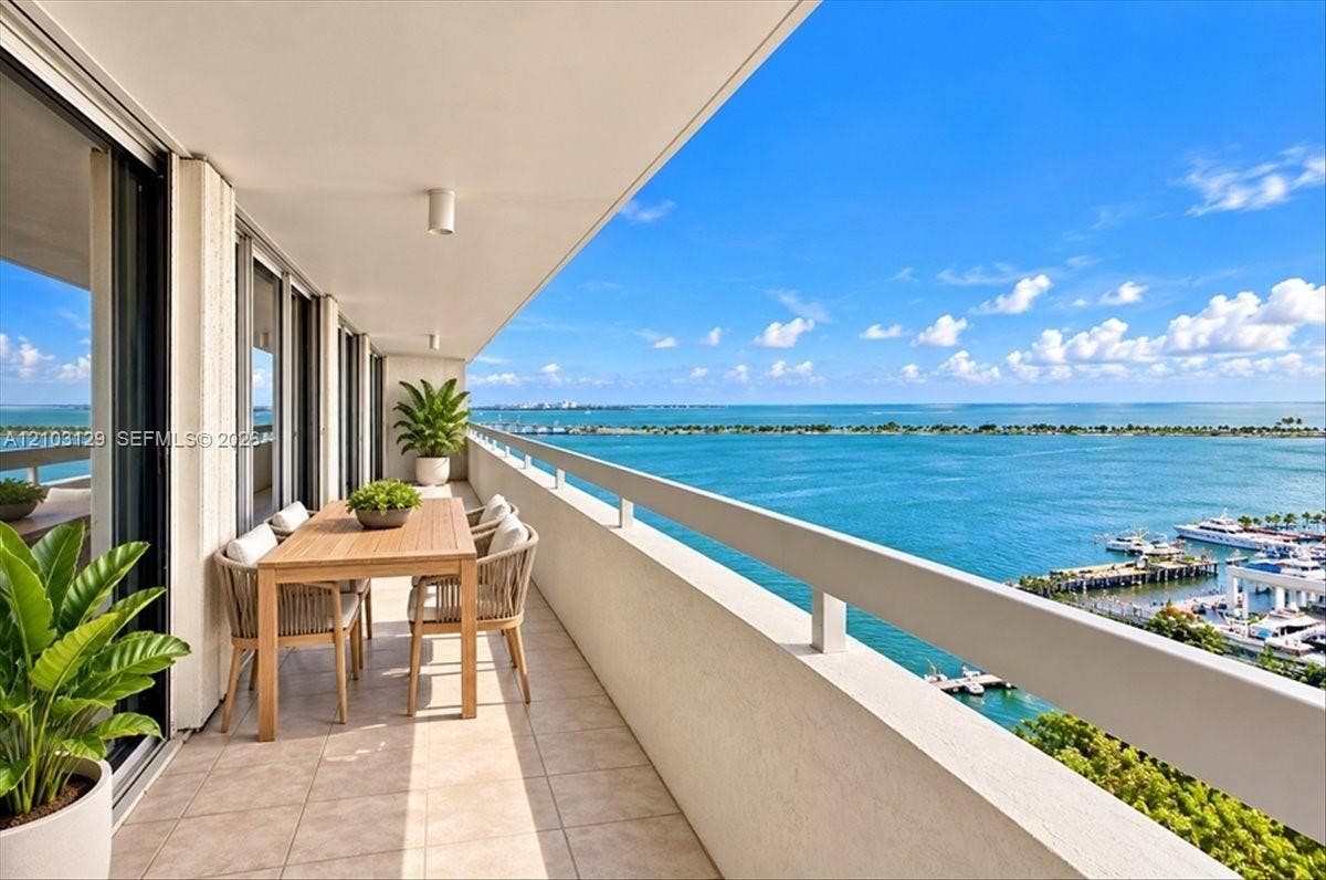 1627 Brickell Avenue, #2005, Miami, FL 33129 Expansive covered balcony featuring tile flooring, metal railings, and direct water and marina scenery