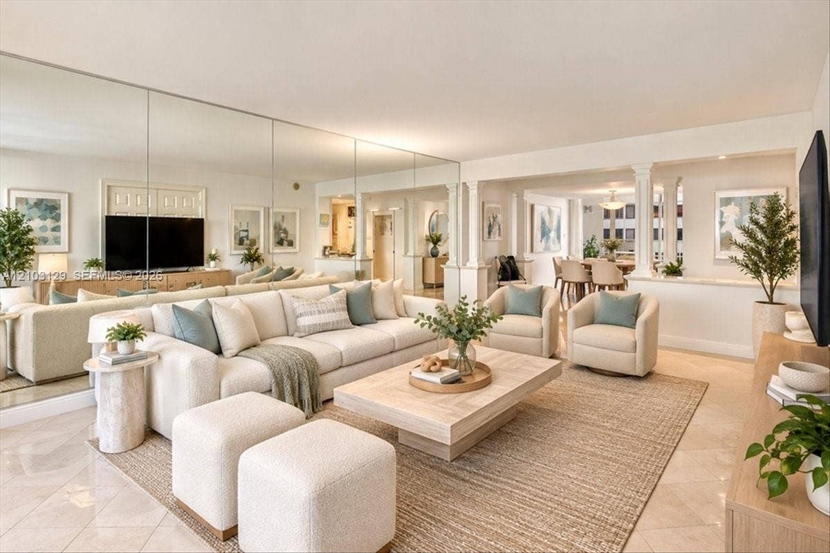 1627 Brickell Avenue, #2005, Miami, FL 33129 Living room featuring full-wall decorative mirrors, polished tile flooring, and architectural columns