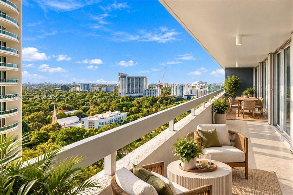 1627 Brickell Avenue, #2005, Miami, FL 33129 Expansive covered terrace featuring tiled flooring, a continuous metal safety railing, and panoramic cityscape and canopy scenery