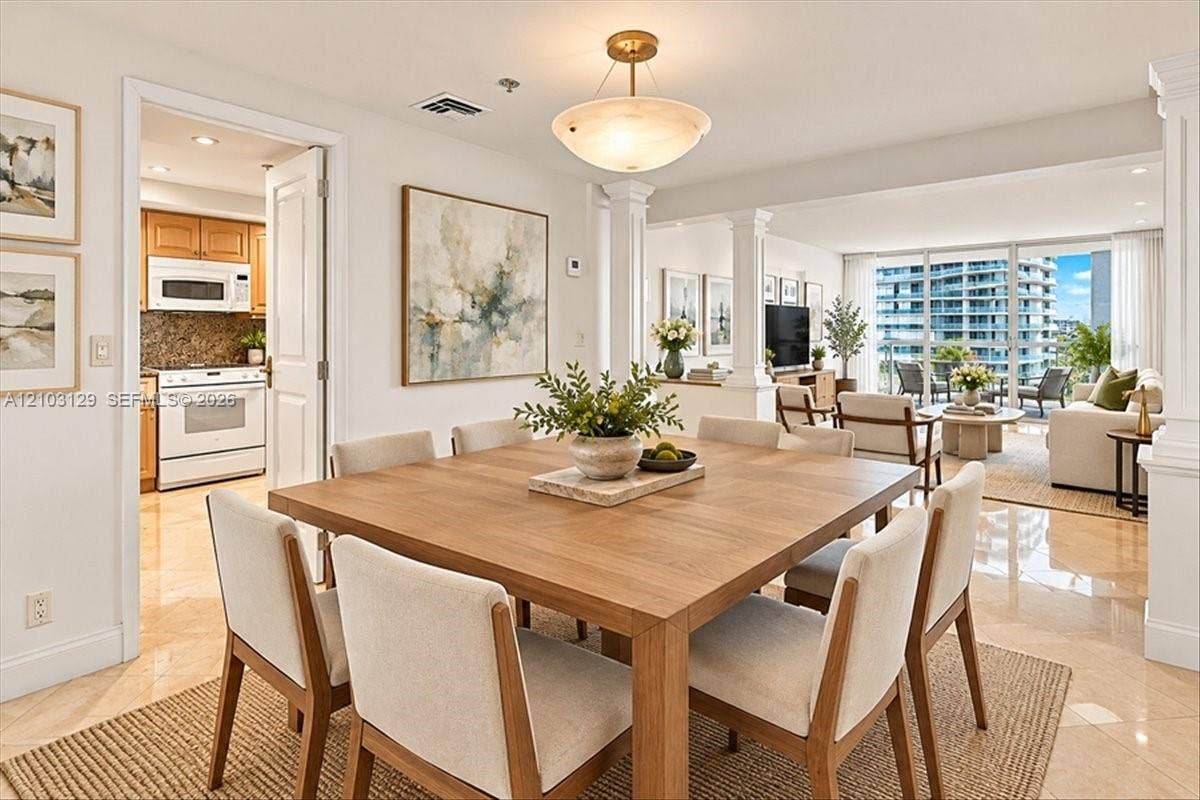 1627 Brickell Avenue, #2005, Miami, FL 33129 Open-concept interior featuring polished stone flooring, recessed architectural columns, and expansive floor-to-ceiling glass paneling