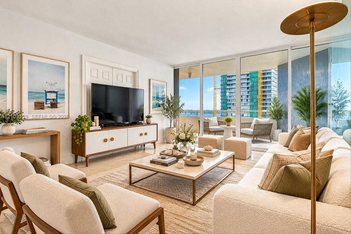 1627 Brickell Avenue, #2005, Miami, FL 33129 Living area featuring floor-to-ceiling glass sliding doors, stone-finish flooring, and an expansive covered balcony