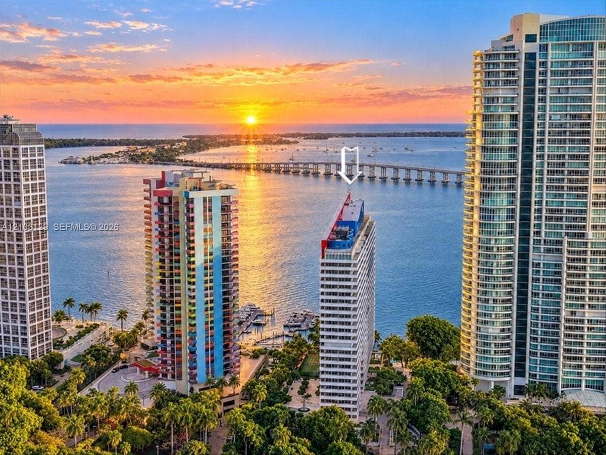 1627 Brickell Avenue, #2005, Miami, FL 33129 High-rise residential tower featuring architectural geometric detailing, balcony facades, and a vibrant sunset backdrop