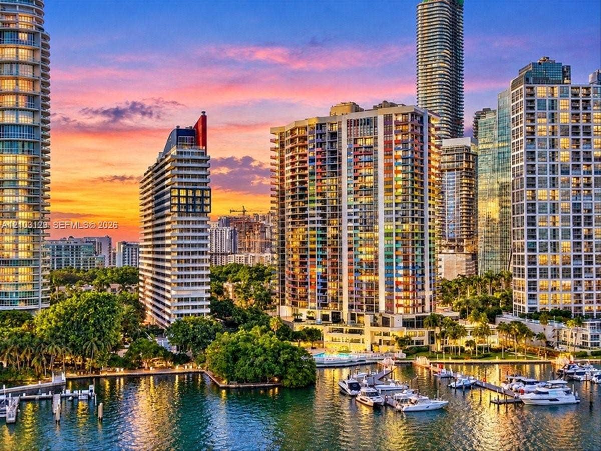 1627 Brickell Avenue, #2005, Miami, FL 33129 High-rise urban landscape featuring multiple glass-facade residential towers, deep-water marina with boat slips, and mature tropical landscaping set against a coastal waterway