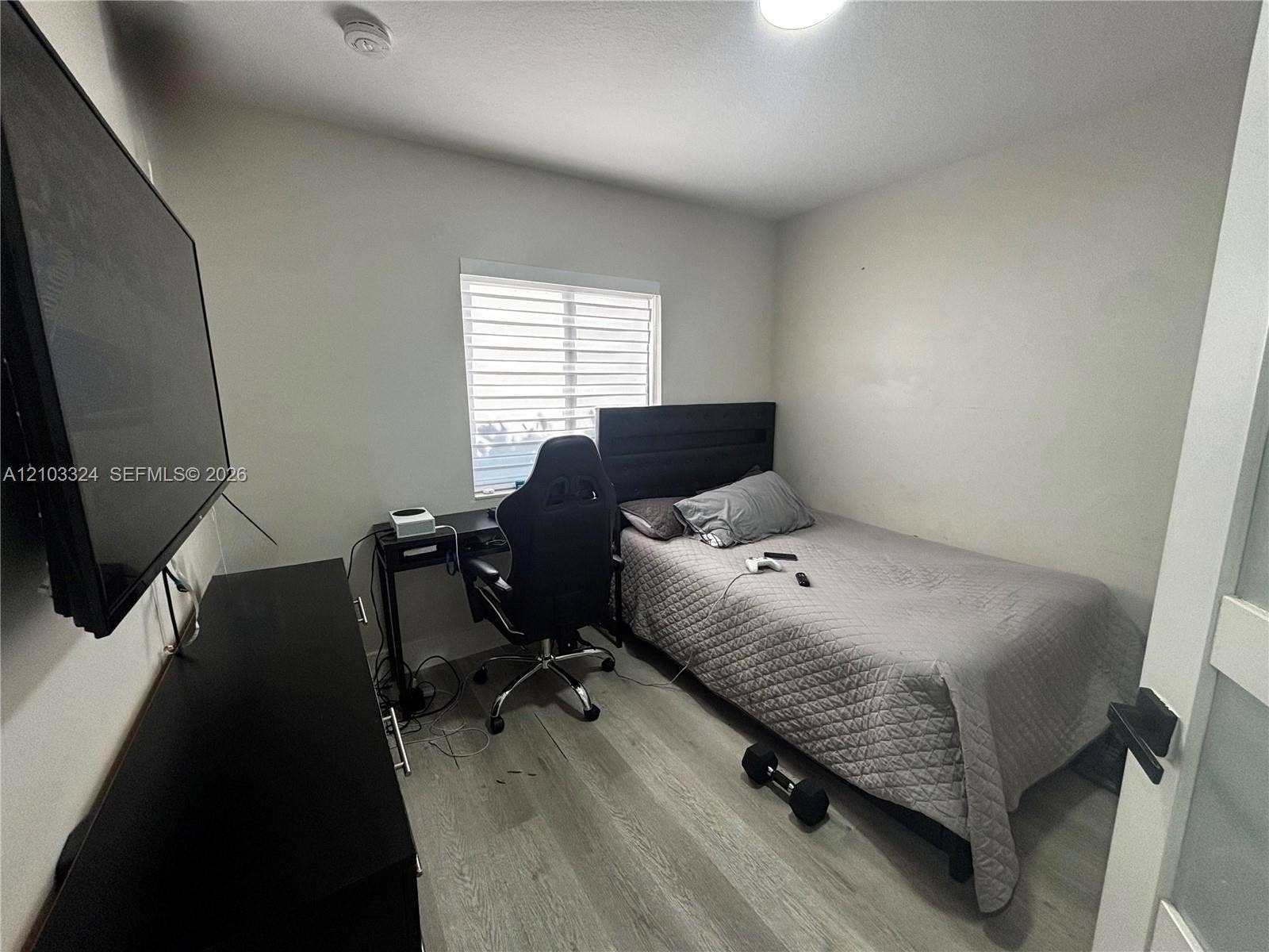 13413 SW 256th Street, Homestead, FL 33032 Bedroom featuring wood-finish flooring, a neutral color palette, and a window with horizontal blinds