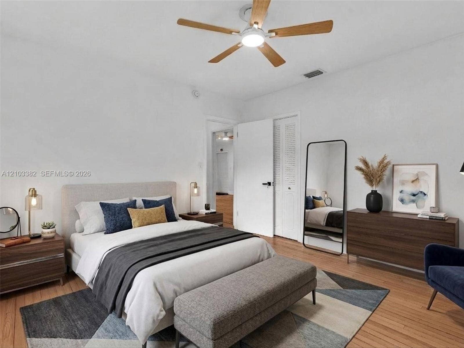 1545 Mantua Avenue, Coral Gables, Coral Gables, FL 33146 VIRTUAL STAGING. East bedroom featuring wood-finish flooring, a ceiling fan with integrated lighting, and louvered-panel closet doors. House for rent in Coral Gables. House for rent listed by Realtor.