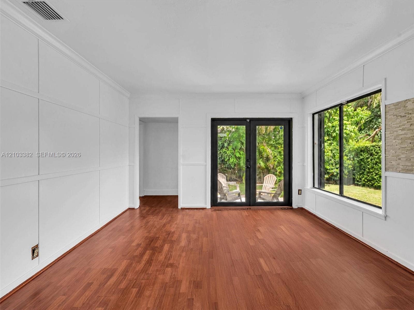 1545 Mantua Avenue, Coral Gables, Coral Gables, FL 33146 Awesome Florida room featuring wood-finish flooring, custom wall paneling, expansive windows, and black-framed double doors. House for rent in Coral Gables. House for rent listed by Realtor