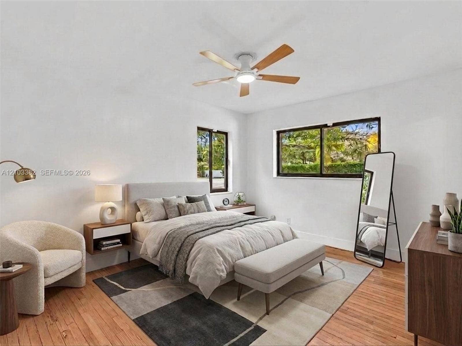 1545 Mantua Avenue, Coral Gables, Coral Gables, FL 33146 VIRTUAL STAGING. Front west bedroom with en-suite bath and closet. Featuring wood-finish flooring, two sliding windows with dark frames, and a ceiling-mounted fan with integrated lighting. House for rent in Coral Gables. House for rent listed by Realtor.