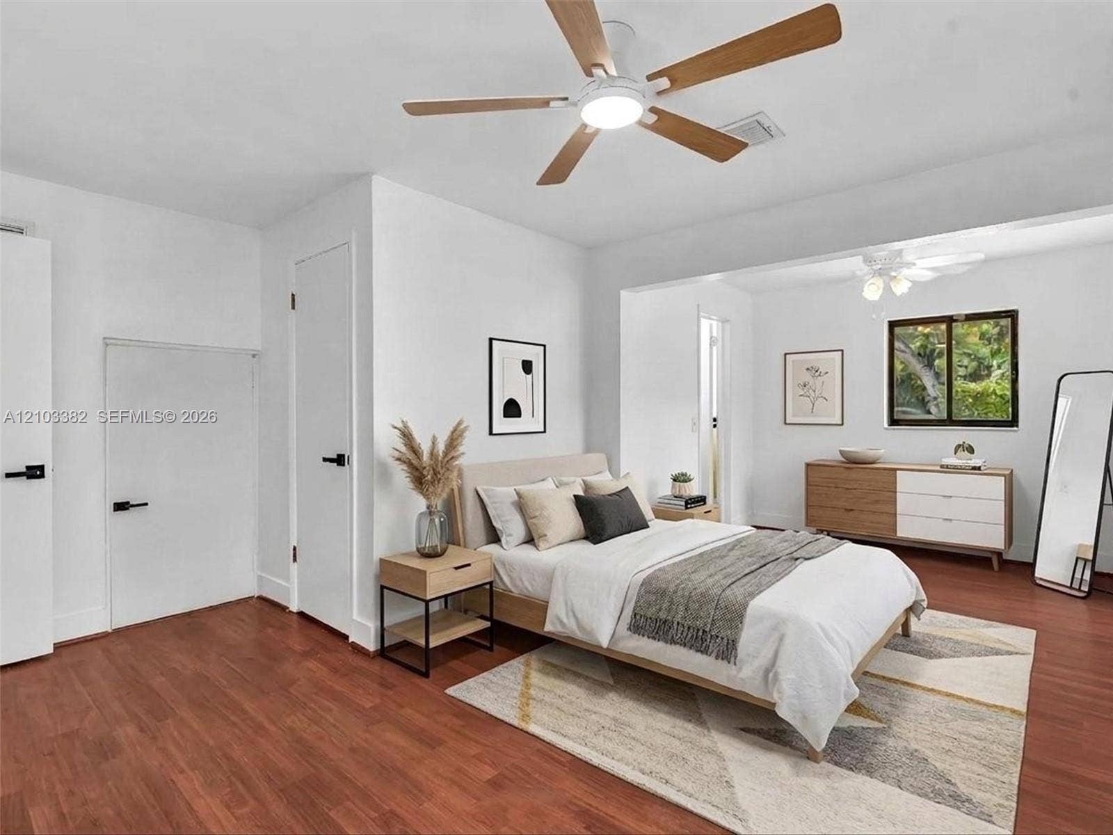 1545 Mantua Avenue, Coral Gables, Coral Gables, FL 33146 VIRTUAL STAGING. Rear private bedroom featuring walk-in closet, en-suite bath, siting area and wood-finish flooring, white doors with matte black hardware, dual ceiling fans, and nice windows. House for rent in Coral Gables. House for rent listed by Realtor.