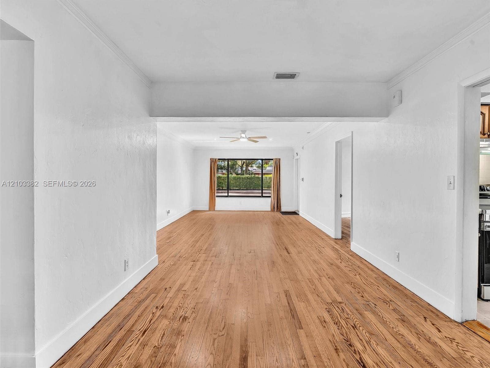 1545 Mantua Avenue, Coral Gables, Coral Gables, FL 33146 Open-concept split interior featuring wood-finish flooring, crisp white wall finishes, crown molding, ceiling fans. House for rent in Coral Gables. House for rent listed by Realtor.