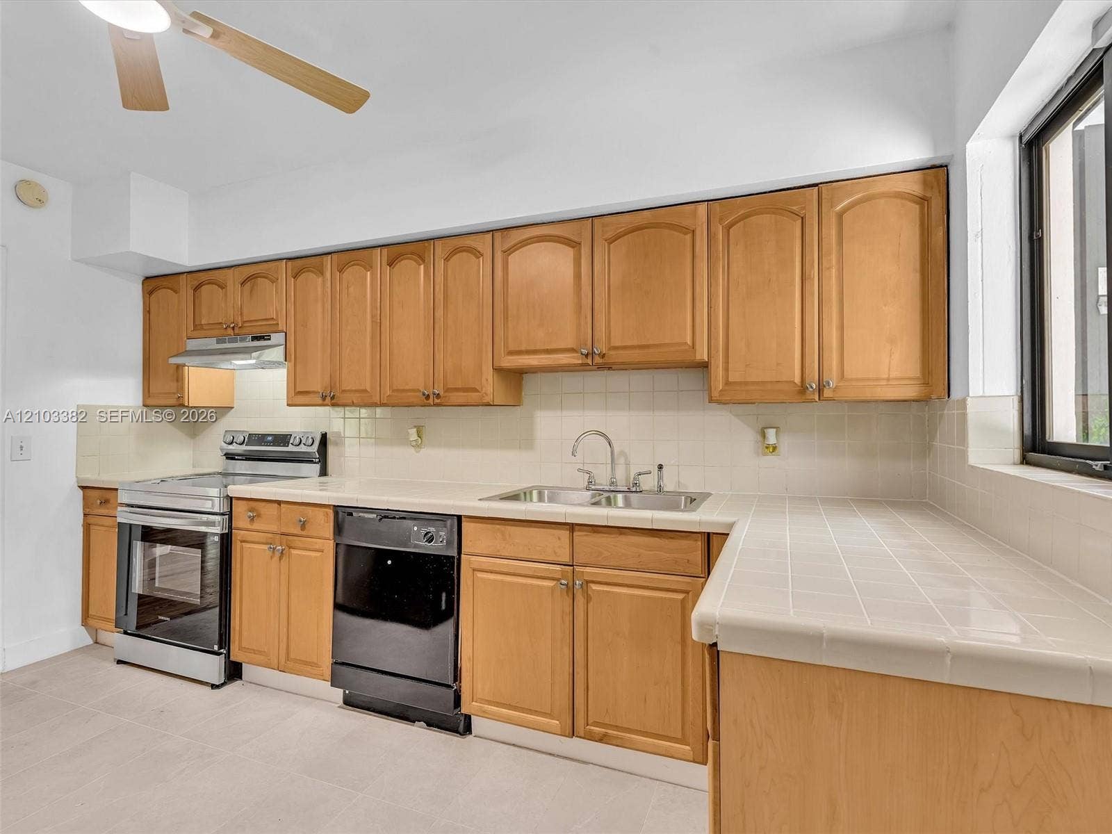1545 Mantua Avenue, Coral Gables, Coral Gables, FL 33146 Kitchen featuring tile countertops, tile backsplash, stainless steel range, and integrated ceiling fan. House for rent in Coral Gables. House for rent listed by Realtor.