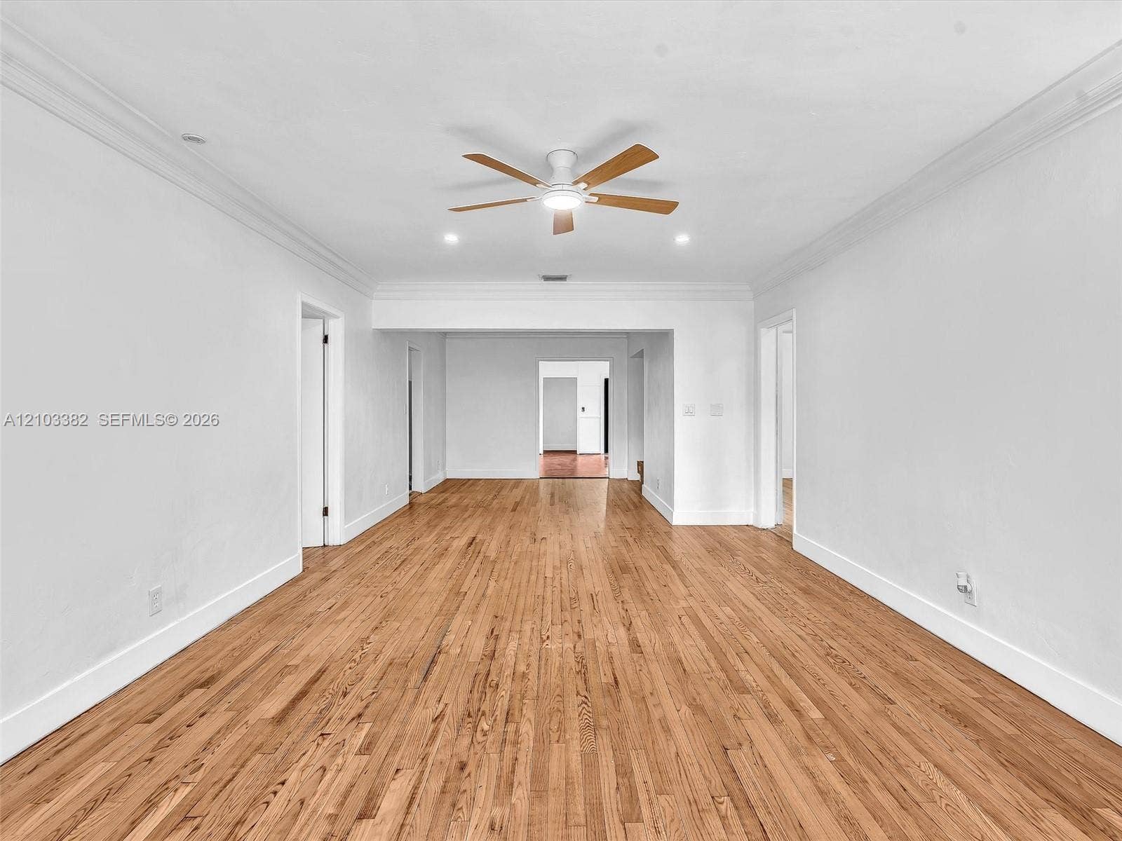 1545 Mantua Avenue, Coral Gables, Coral Gables, FL 33146 Sunny living room and dining room featuring wood-finish flooring, crown molding, recessed lighting, and ceiling fans. Home has a split design, separating the 4 bedrooms. House for rent in Coral Gables. House for rent listed by Realtor