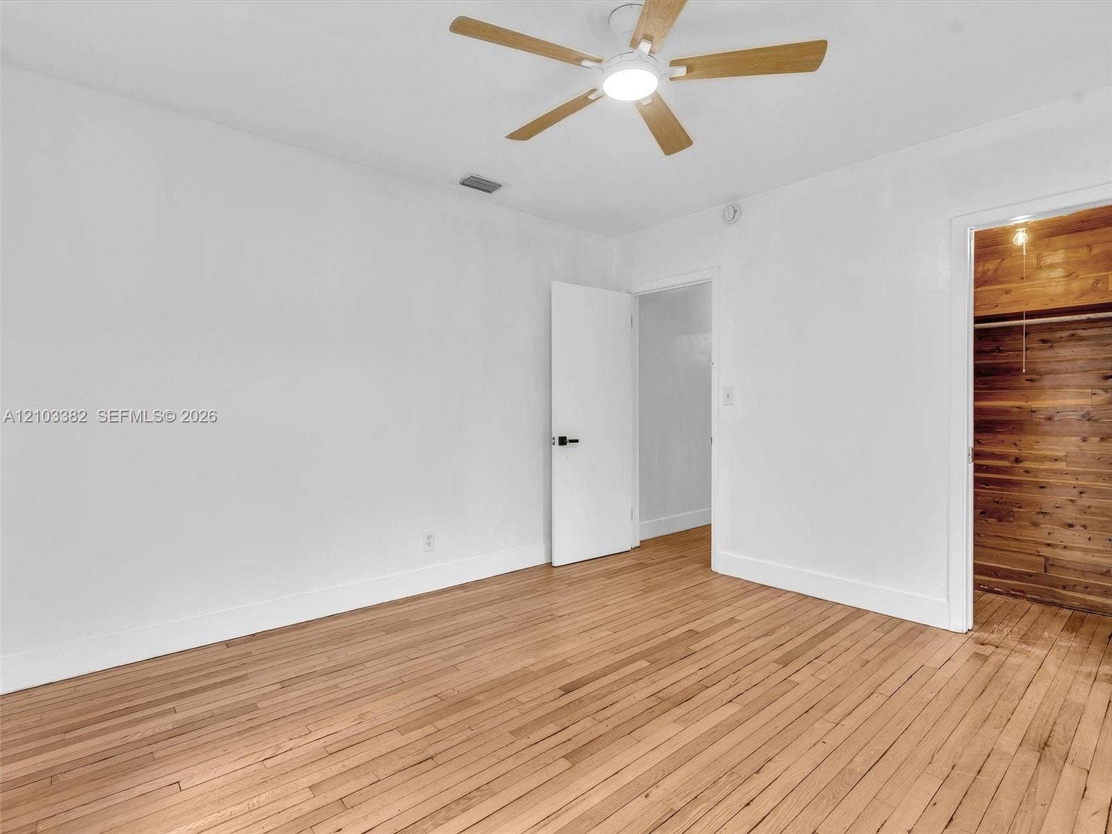 1545 Mantua Avenue, Coral Gables, Coral Gables, FL 33146 Front east bedroom featuring wood-finish flooring, a ceiling fan with integrated lighting, and a closet finished with wood paneling.House for rent in Coral Gables. House for rent listed by Realtor.