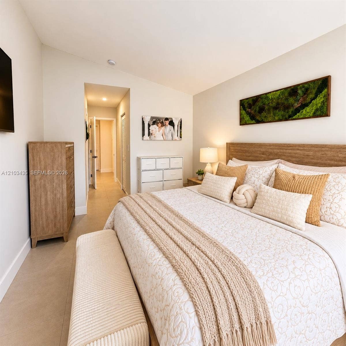 Miami, FL 33177 Neutral-toned interior space featuring light-colored tile flooring, a slanted ceiling, and a built-in wood-finish headboard