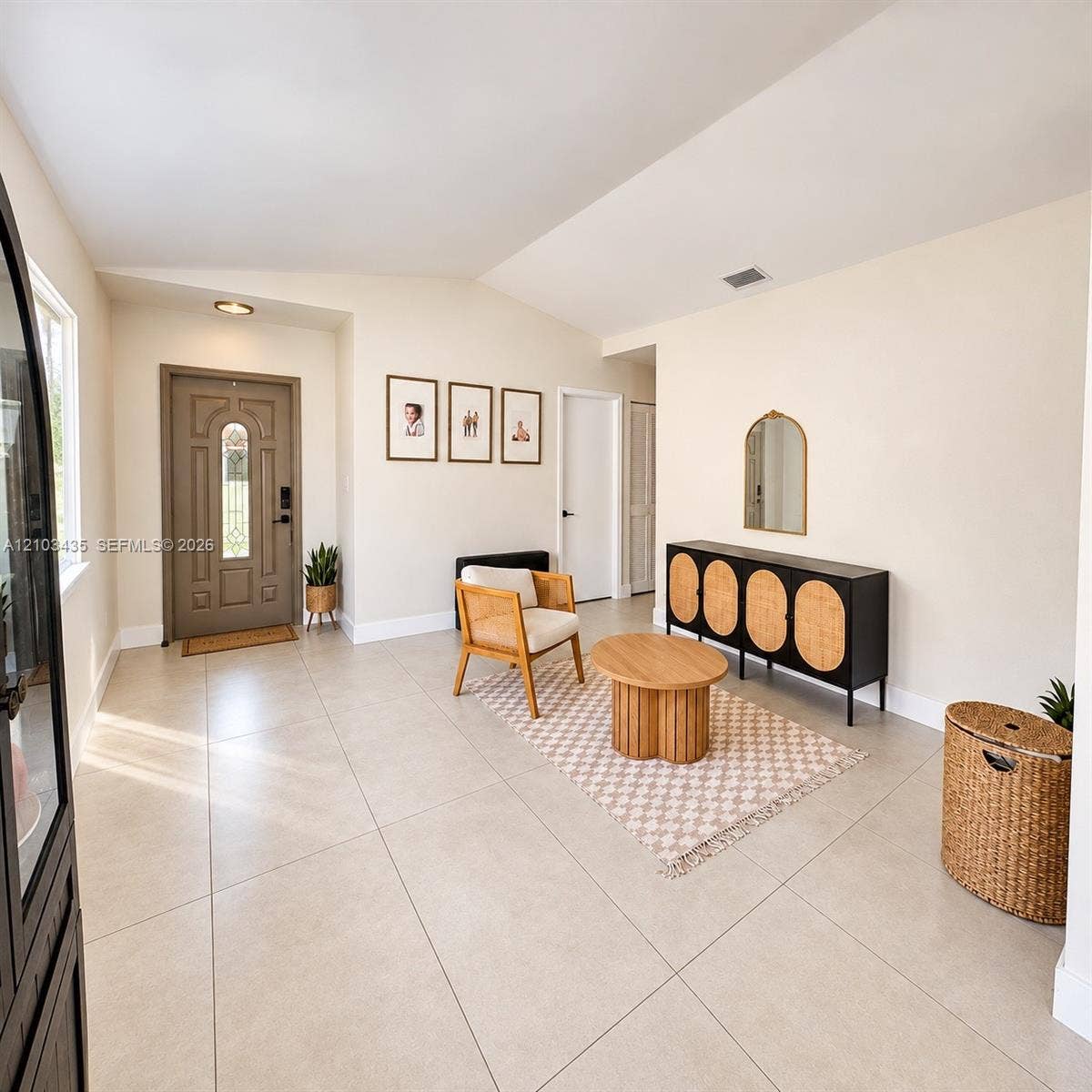 Miami, FL 33177 Entryway featuring large-format neutral floor tile, vaulted ceilings, and a paneled front door with decorative glass inlay