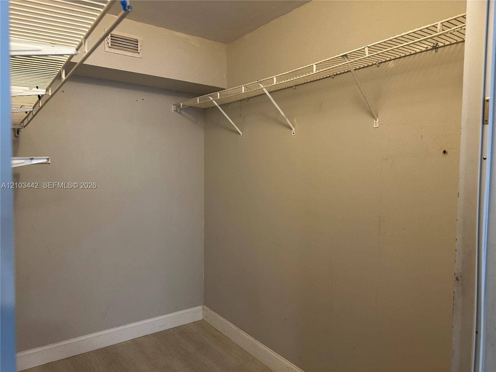 8721 Wiles Road, #303, Coral Springs, FL 33067 Storage space featuring wall-mounted wire shelving and neutral-toned wall paint