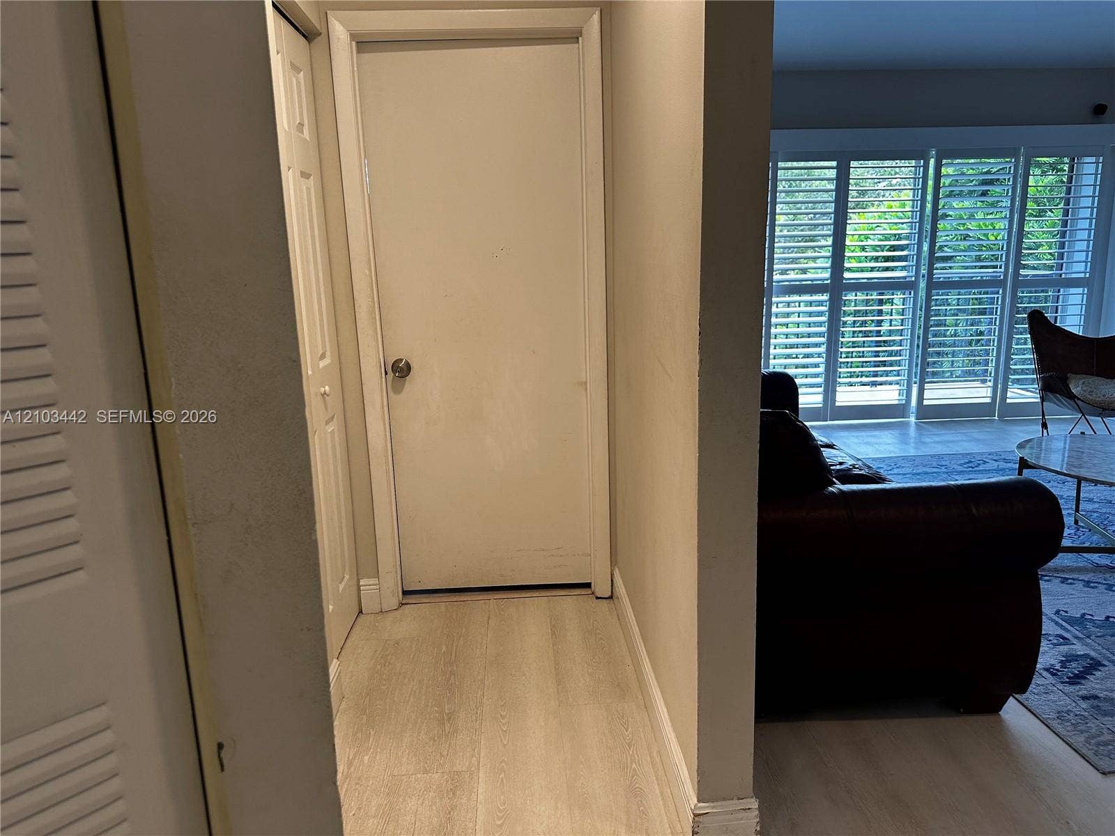 8721 Wiles Road, #303, Coral Springs, FL 33067 Wood-finish flooring, interior louvered bi-fold doors, and expansive floor-to-ceiling glass panel doors with interior shutters